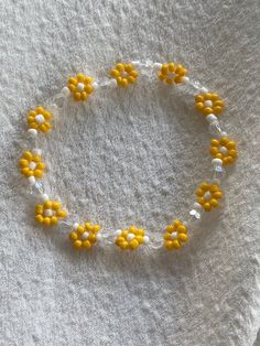 a yellow and white beaded bracelet with flowers