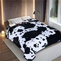 a black and white cow print comforter on a bed