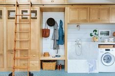 a laundry room with wooden cabinets and ladder