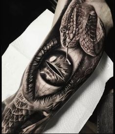 a man's arm with an eye and snake on it