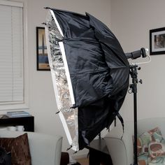 a black umbrella sitting on top of a white chair