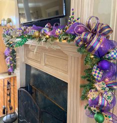 a fireplace decorated with purple and green christmas decorations