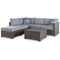 an outdoor sectional sofa with ottomans and pillows on the bottom row, in front of a white background