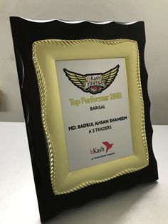 a black and gold frame with an award on it