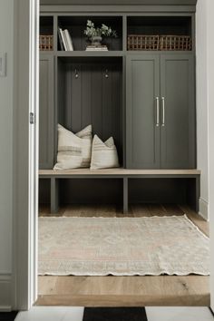 the entryway is decorated in gray and white with lots of storage space on either side