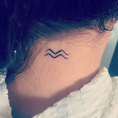 a woman's neck with a small tattoo on it