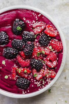 a white bowl filled with berries and blackberries