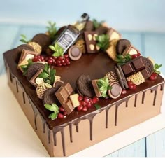 a heart shaped cake decorated with chocolates and berries