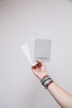 a hand holding three sheets of white paper