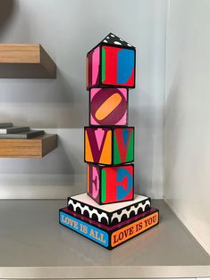 a stack of colorful blocks sitting on top of a table next to some bookshelves