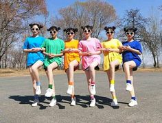 five young people in colorful outfits are posing for the camera