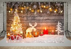 a christmas scene with candles and presents in the snow on a brick wall behind it