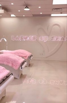 there are two beds with pink blankets on them in the room that is lit up