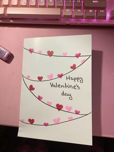 a valentine's day card on a desk next to a keyboard