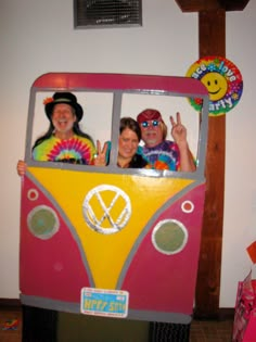 three people in a bus costume posing for the camera with peace signs on their faces