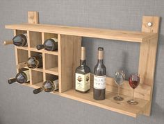 a wooden shelf with wine bottles and glasses on it next to a wall mounted wine glass holder