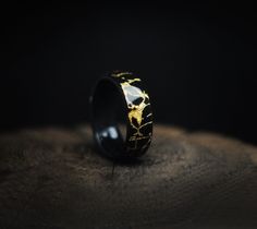 "Kintsugi (金継ぎ, \"golden joinery\"), also known as kintsukuroi (金繕い, \"golden repair\"), is the Japanese art of repairing broken pottery by mending the areas of breakage with gold. Kintsugi was my inspiration when creating this ring, reminding me that sometimes when things fall apart, they can become even more beautiful when mended. Kintsugi Gold Leaf & Ebony Wooden Ring is a ring made from ebony wood with an intricate design of cracks, filled with golden leaf. Lightweight, elegant and comfortab Beautiful Wedding Rings, Gold Powder, Men's Wedding Ring, Art Japonais, Wooden Ring, Ebony Wood, Wooden Rings, One Ring, Wood Jewellery