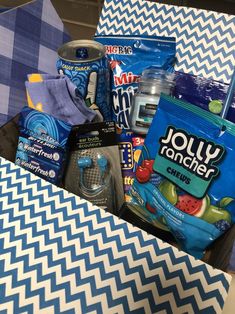 the contents of a diaper bag sitting on top of a blue and white checkered tablecloth