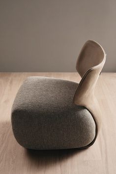 an upholstered chair sitting on top of a wooden floor