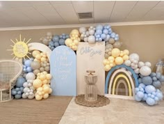 a room decorated with balloons and archs for a baby's first birthday party