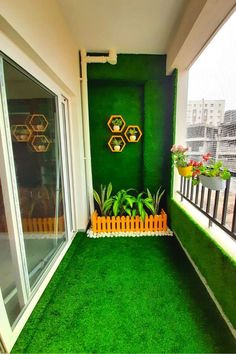 an apartment balcony with artificial grass and potted plants