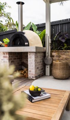 an outdoor pizza oven with lemons on the table