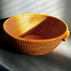 a yellow basket sitting on top of a table next to a black wall and floor