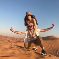 a man riding on top of a woman in the desert