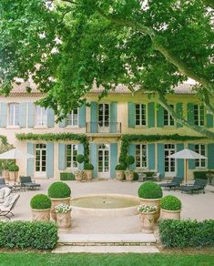 a large house with blue shutters and green trees