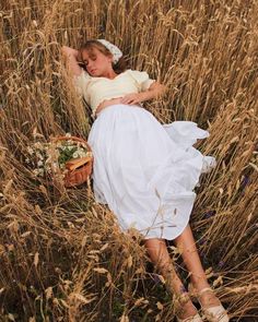 a woman is laying in the tall grass