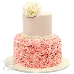 a pink and white cake with flowers on top