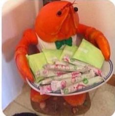 an orange stuffed animal sitting on top of a blue and white bowl filled with candy