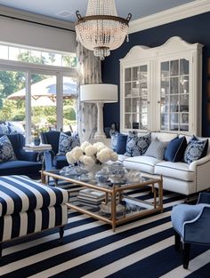 a living room with blue and white furniture, striped rugs and chandelier