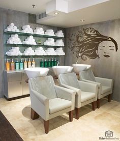 two white chairs sitting in front of a wall with shelves filled with hair care products