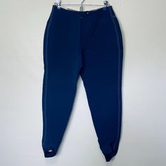 a blue pants hanging on a hanger against a white wall with the bottom part of it