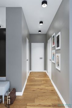 an empty hallway with grey walls and pictures on the wall