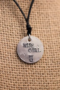 "If you didn't already know, one of the lead female heroines is Annabeth Chase, daughter of Athena. In the Lightning Thief, she's given the nickname \"Wise Girl\" by the lead hero, Percy Jackson. I present to you, my Percy Jackson inspired \"Wise Girl\" necklace. PRODUCT INFORMATION: - Made on a 1 inch aluminum blank (wearer friendly) - Hangs on a black adjustable cord, about 26 inches at the largest setting - The words \"WISE GIRL\" and an owl are stamped on the pendant - Pendant made to look b Inspirational Adjustable Nickel-free Charm Necklaces, Adjustable Inspirational Nickel-free Charm Necklace, Adjustable Hand Stamped Metal Necklace, Adjustable Hand Stamped Necklace, Adjustable Symbolic Charm Necklaces, Annabeth Aesthetic, Percy Jackson Jewelry, Percy Jackson Crafts, Chase Aesthetic