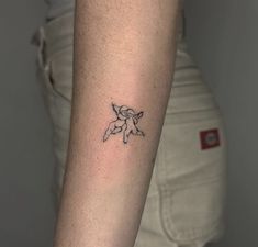 a woman's arm with a small flower tattoo on the left side of her arm