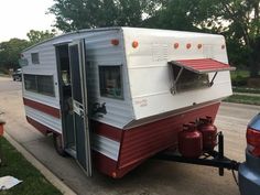 an old camper is parked on the side of the road with its door open