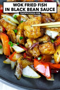 chicken stir fry with vegetables and chopsticks in a black bowl on a table