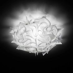 an artistic light fixture in the shape of a flower on a black background with clouds