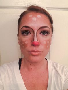 a woman with white dots on her face and pink nose is looking at the camera