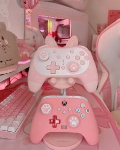 a pink nintendo wii game controller sitting on top of a desk