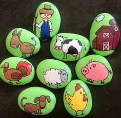 painted rocks with farm animals on them and a man standing in the middle surrounded by other rocks