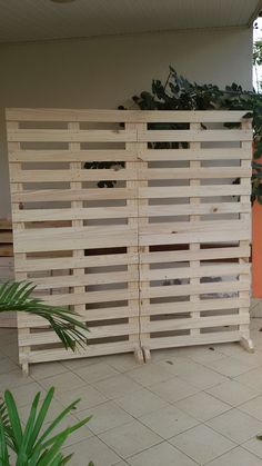 a large wooden fence sitting next to a planter on top of a tiled floor