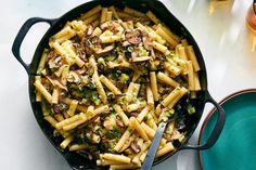 a skillet filled with pasta and mushrooms