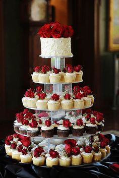 a tiered cake with cupcakes and roses on it