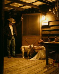 a man standing next to a woman in a room with a dog on the floor