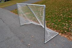 a soccer goal sitting on the side of a road