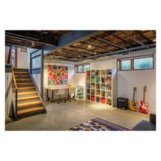 a living room filled with furniture and lots of bookshelves next to a stair case